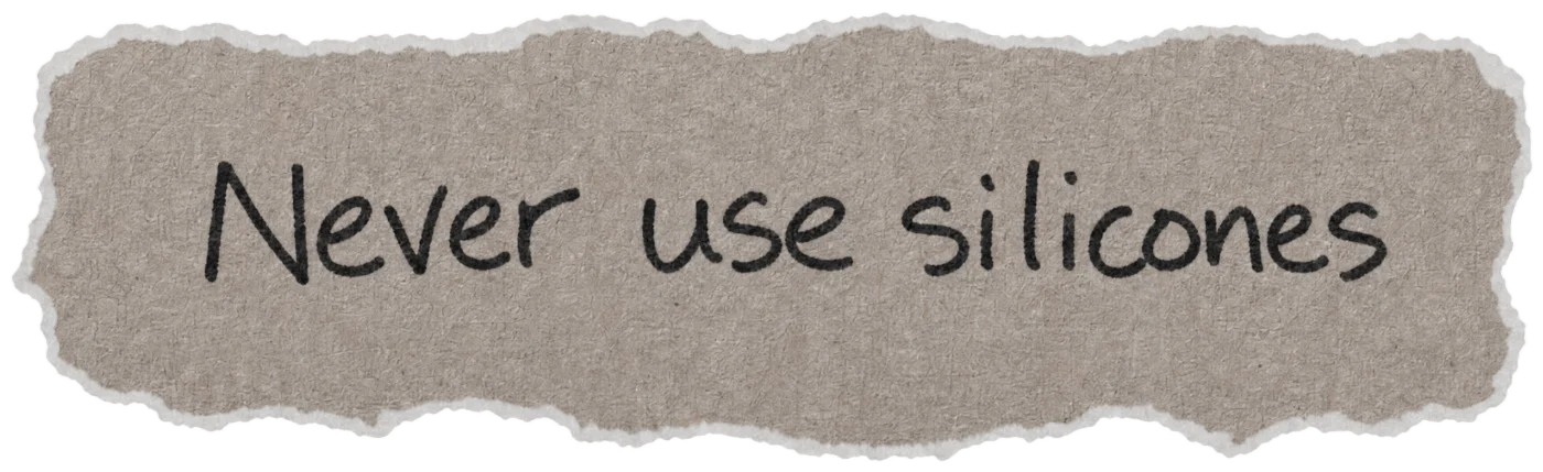 Torn paper note with the handwritten hair myth: Never use silicones